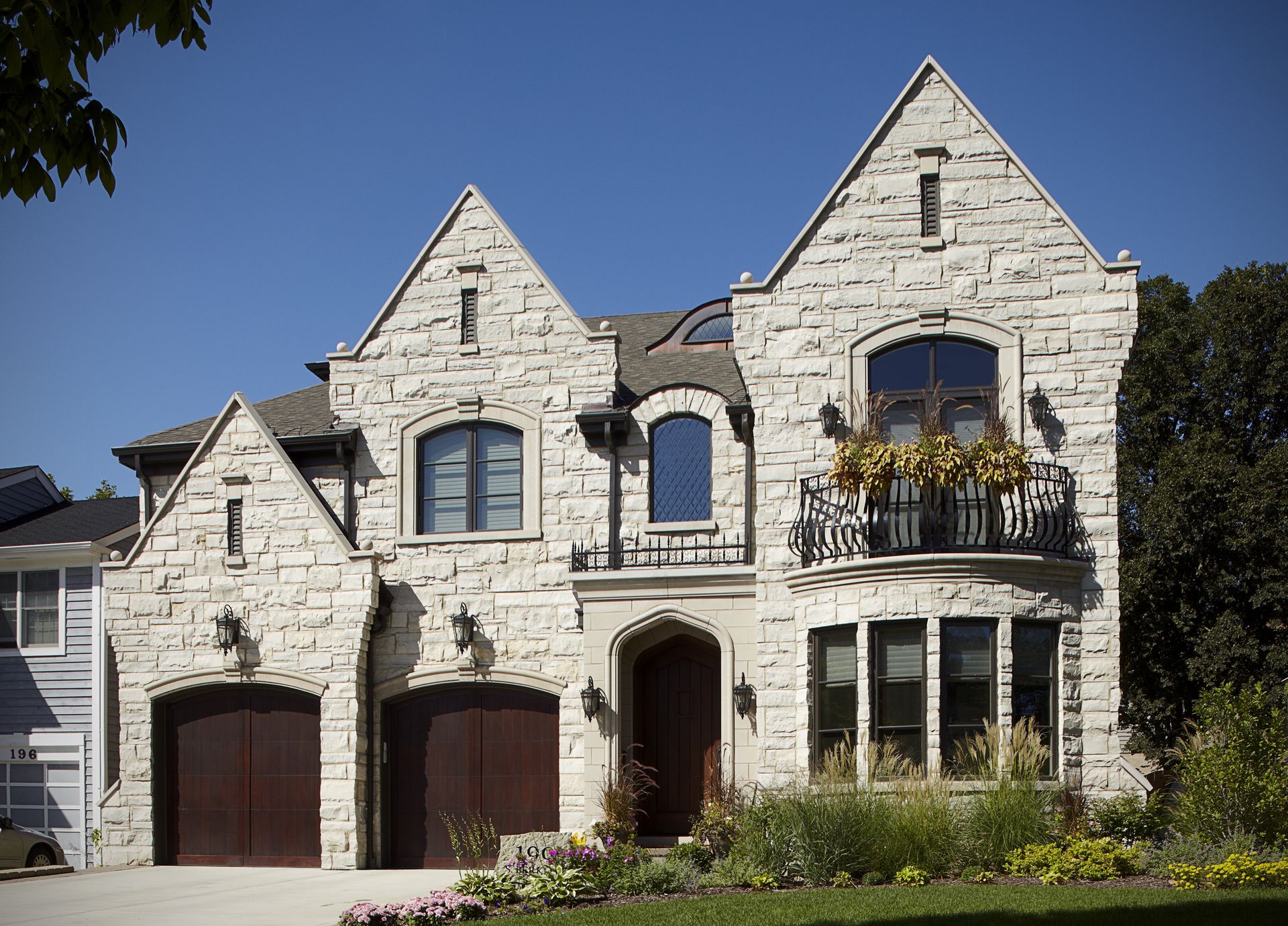 A large brick house with two garages and a balcony