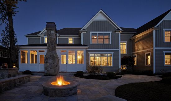 A large house with a fire pit in front of it