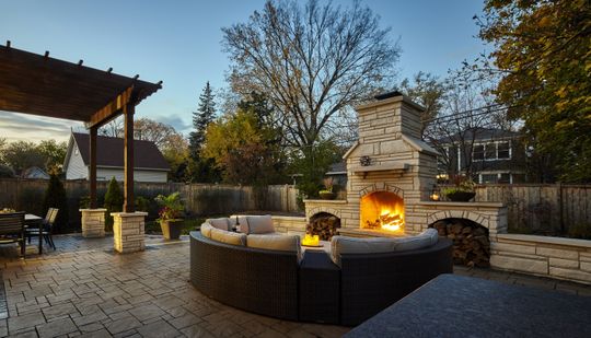 A patio with a fireplace and a couch in the middle