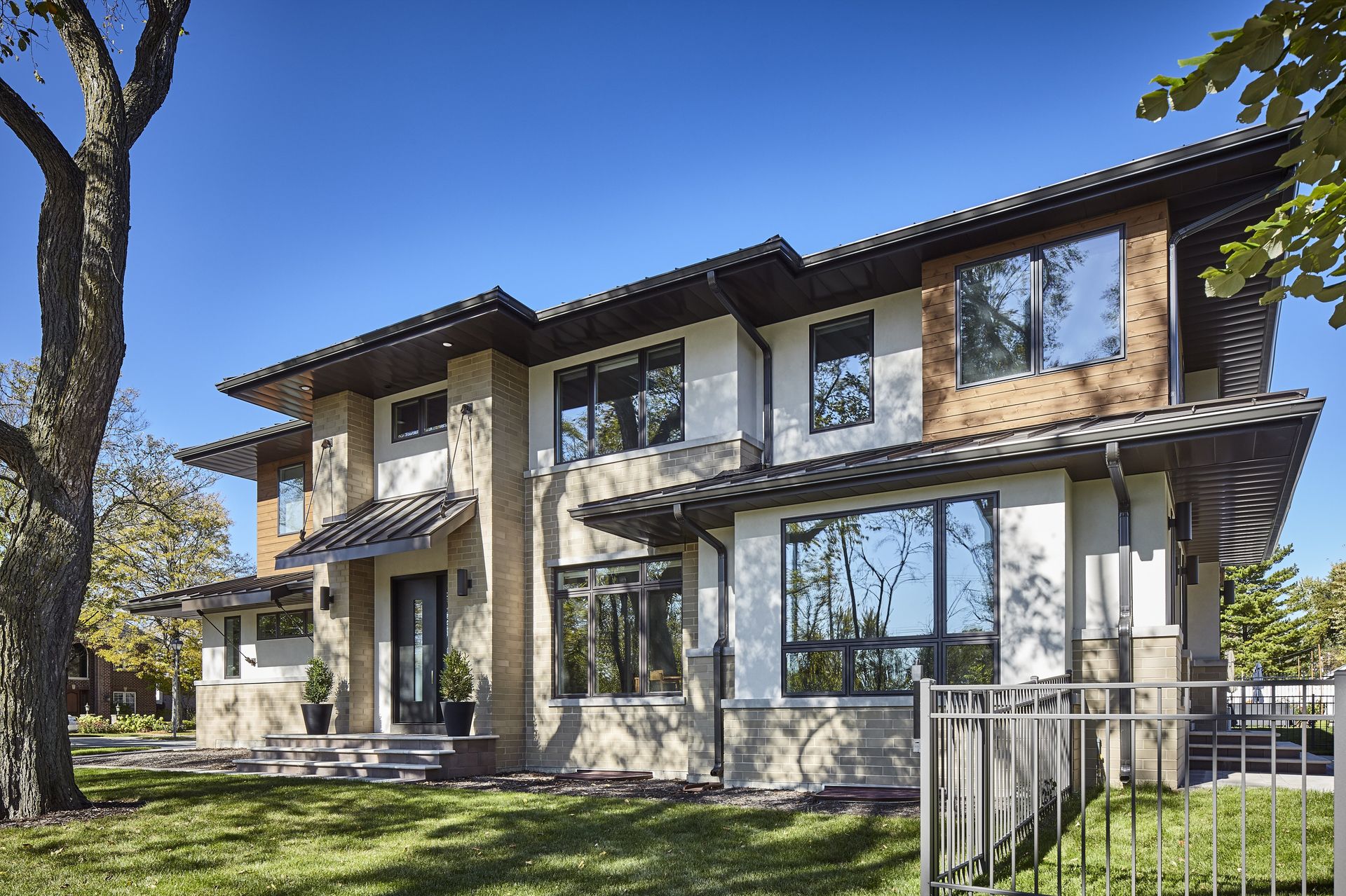 A large house with a lot of windows and a fence in front of it.