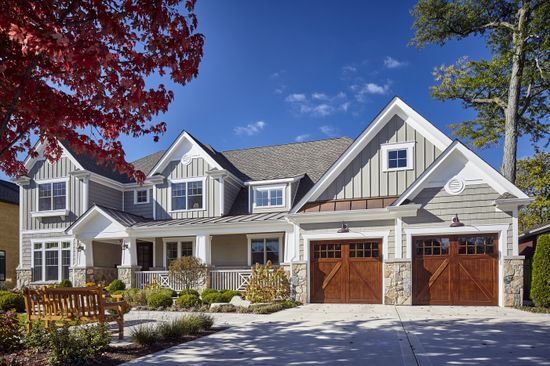 A large house with two garage doors and a porch