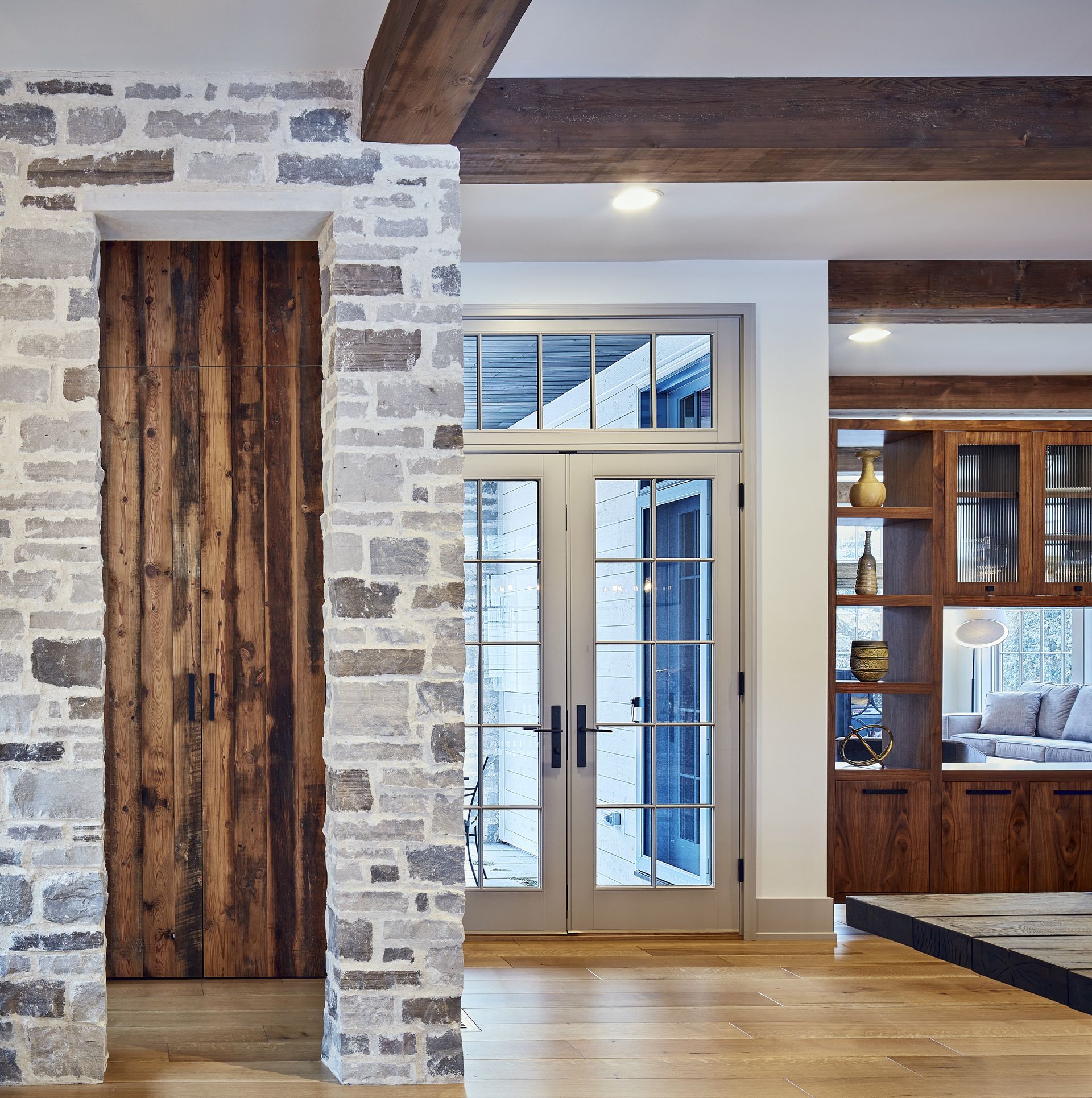 A living room with a brick wall and wooden doors