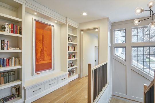 A hallway with bookshelves and a picture on the wall.