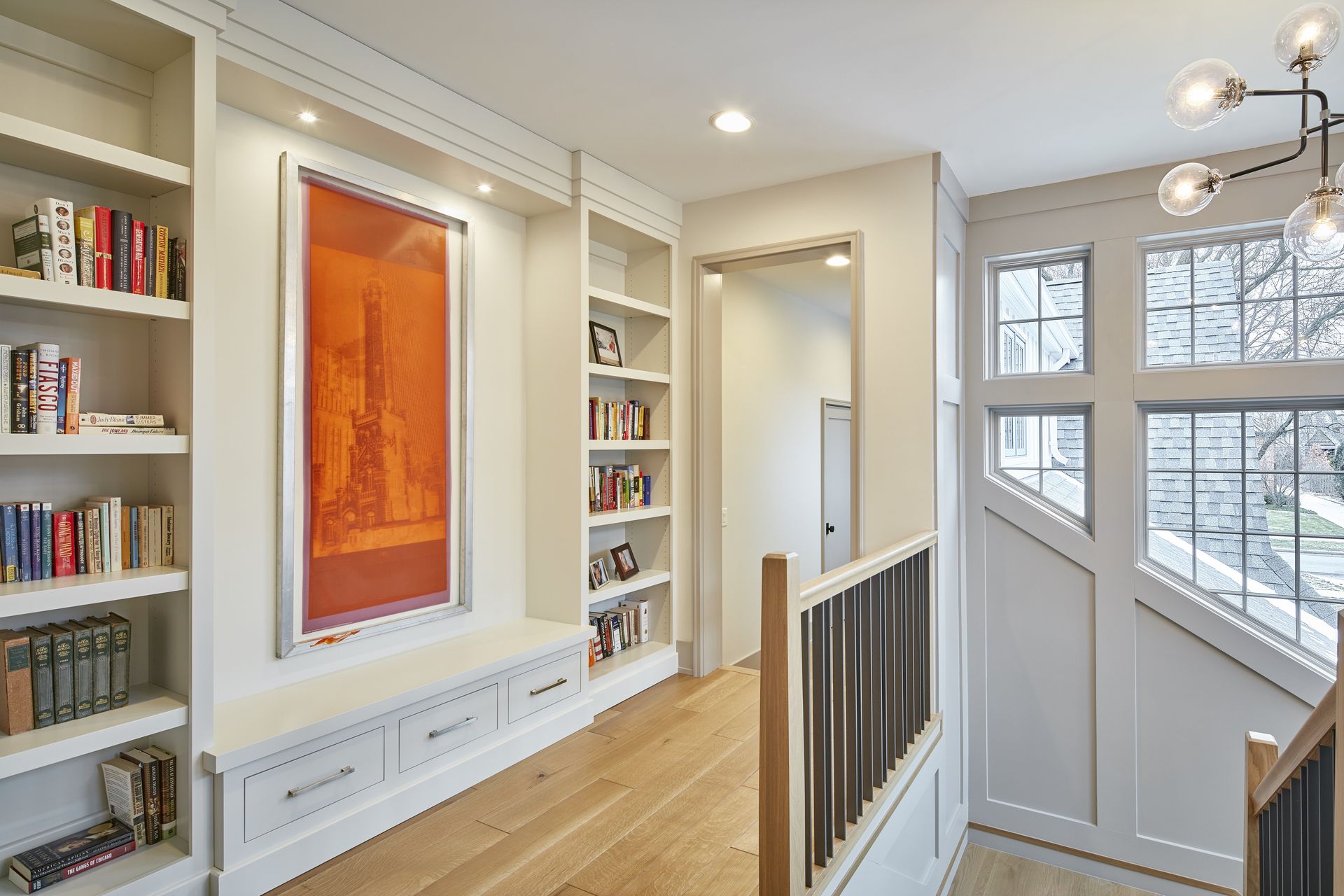 A hallway with bookshelves and a picture on the wall.