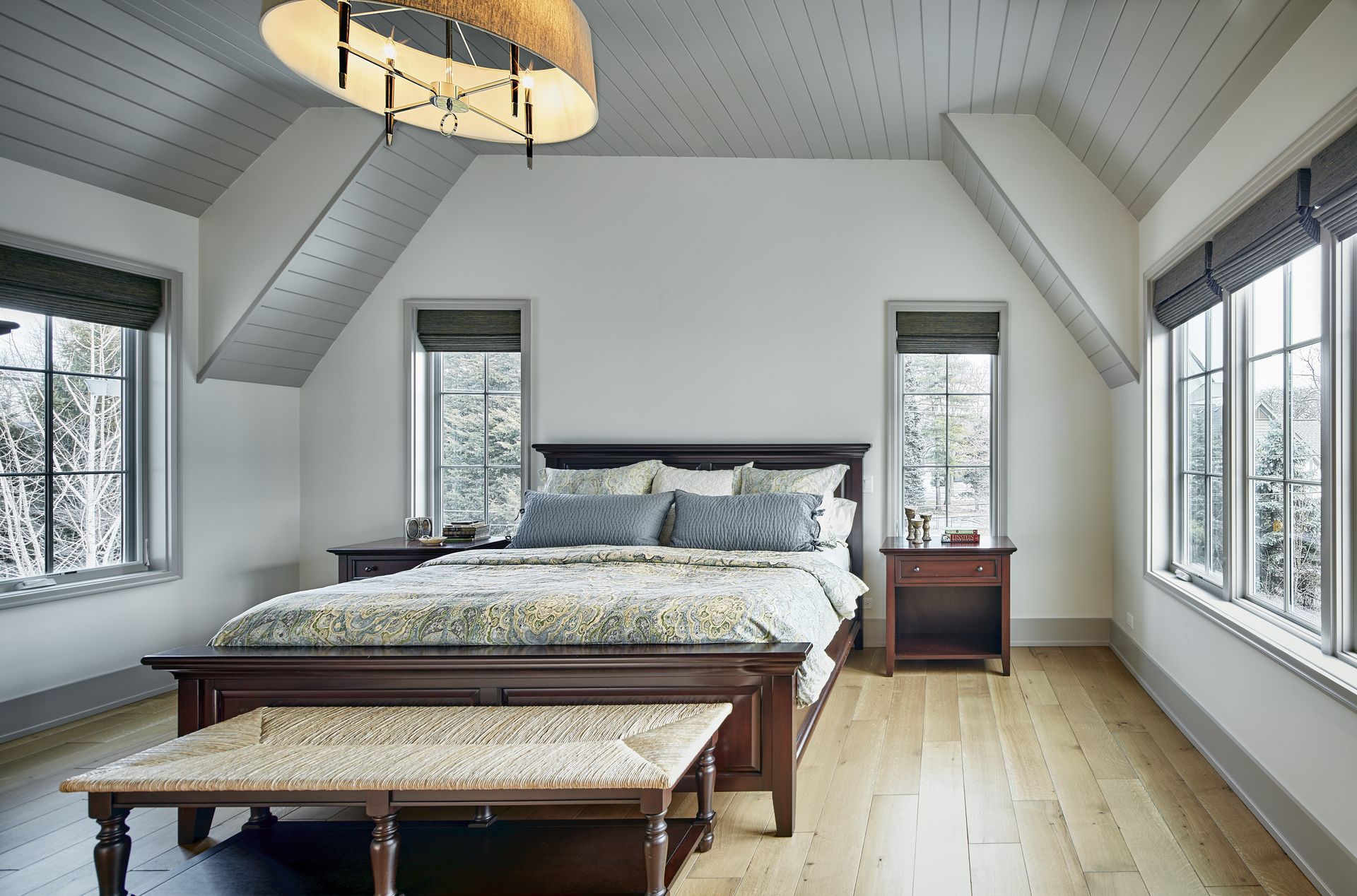A bedroom with a king size bed , nightstands , and a bench.