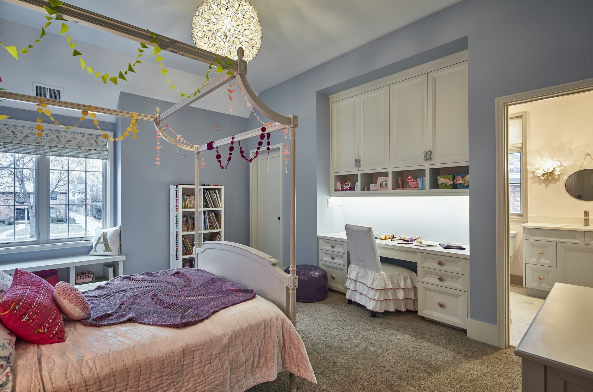 A girl is laying on a bed in a bedroom with a canopy bed.