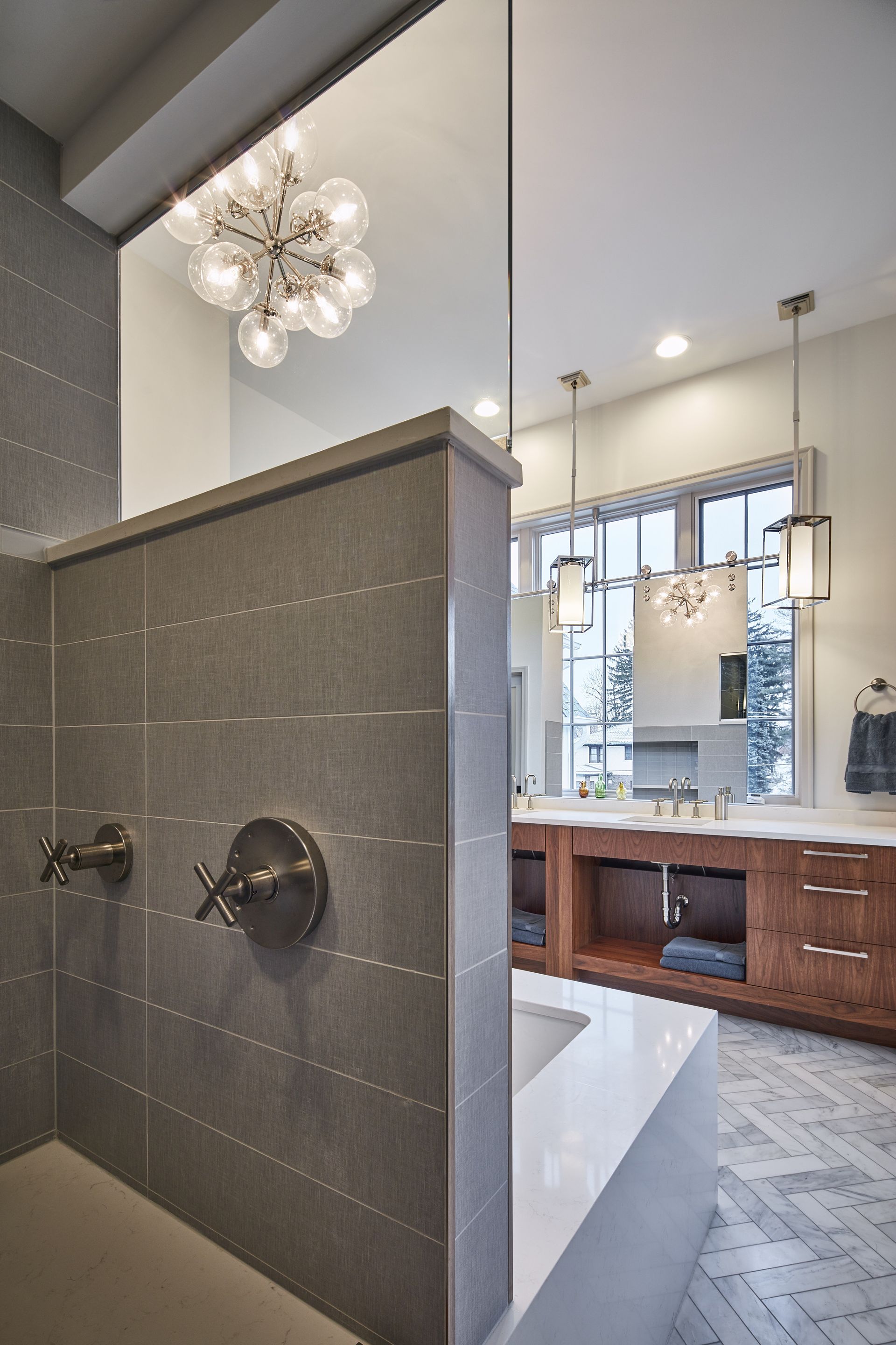 A bathroom with a walk in shower and a sink.