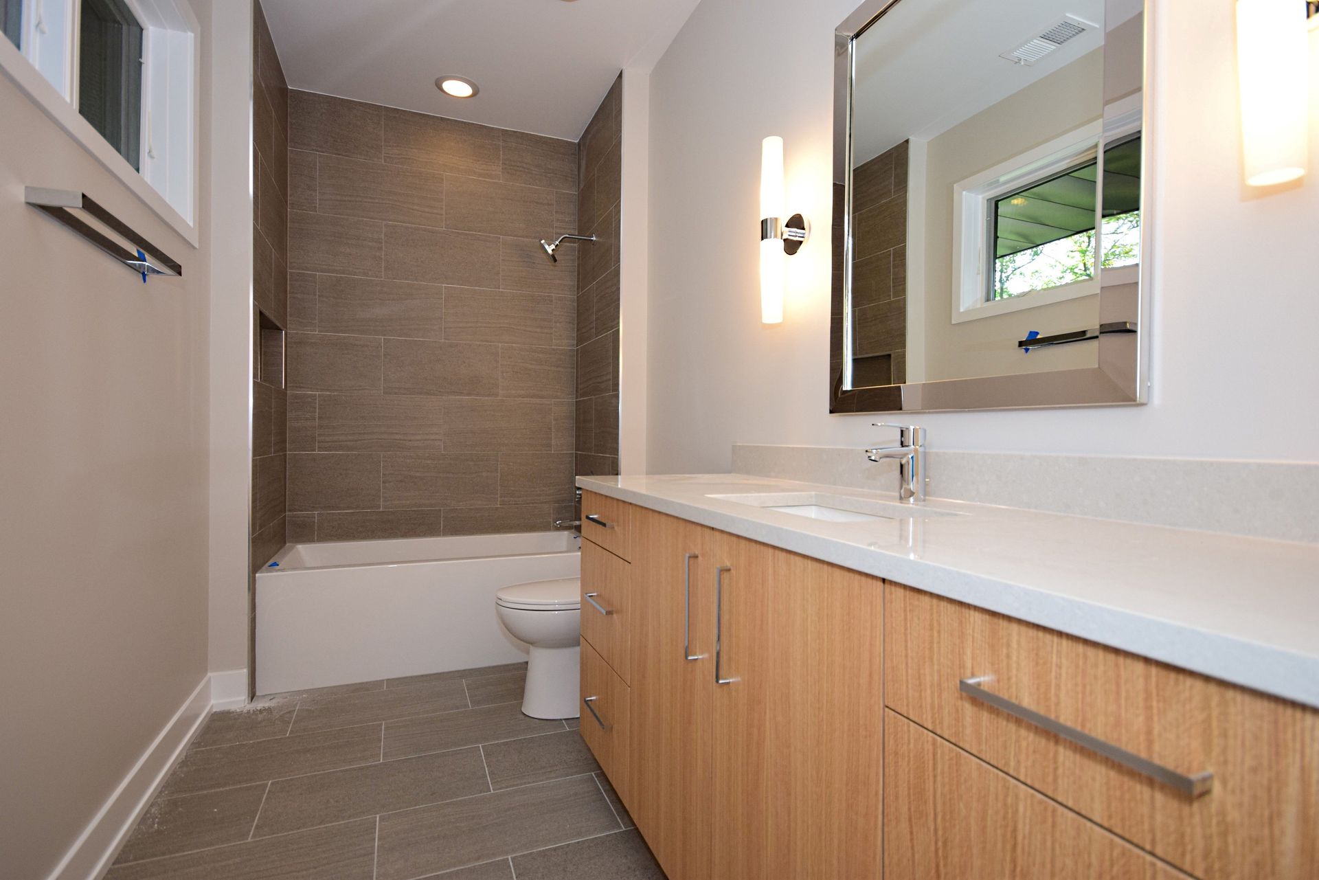 A bathroom with a toilet , sink and mirror