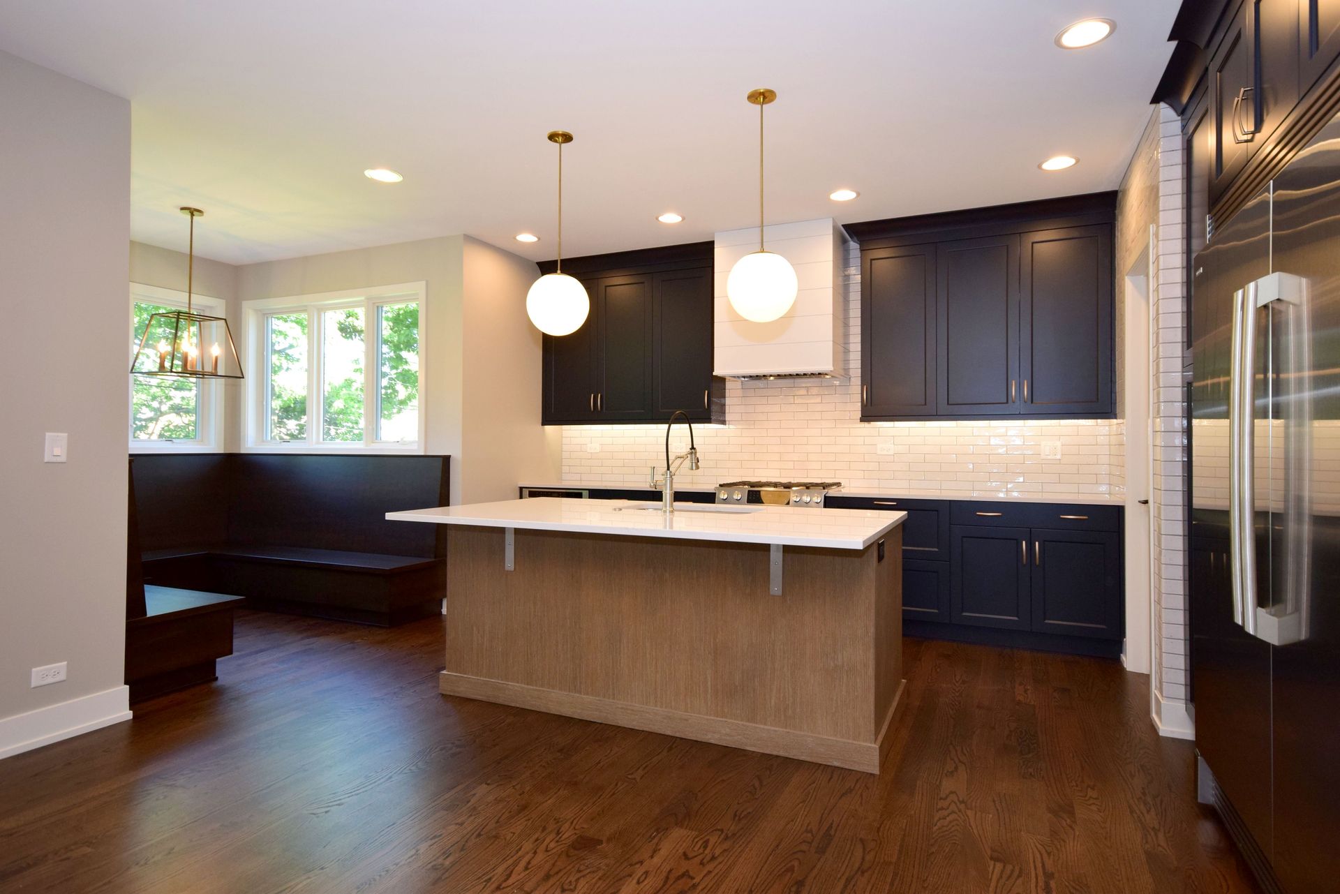 A kitchen with black cabinets and a large island in the middle