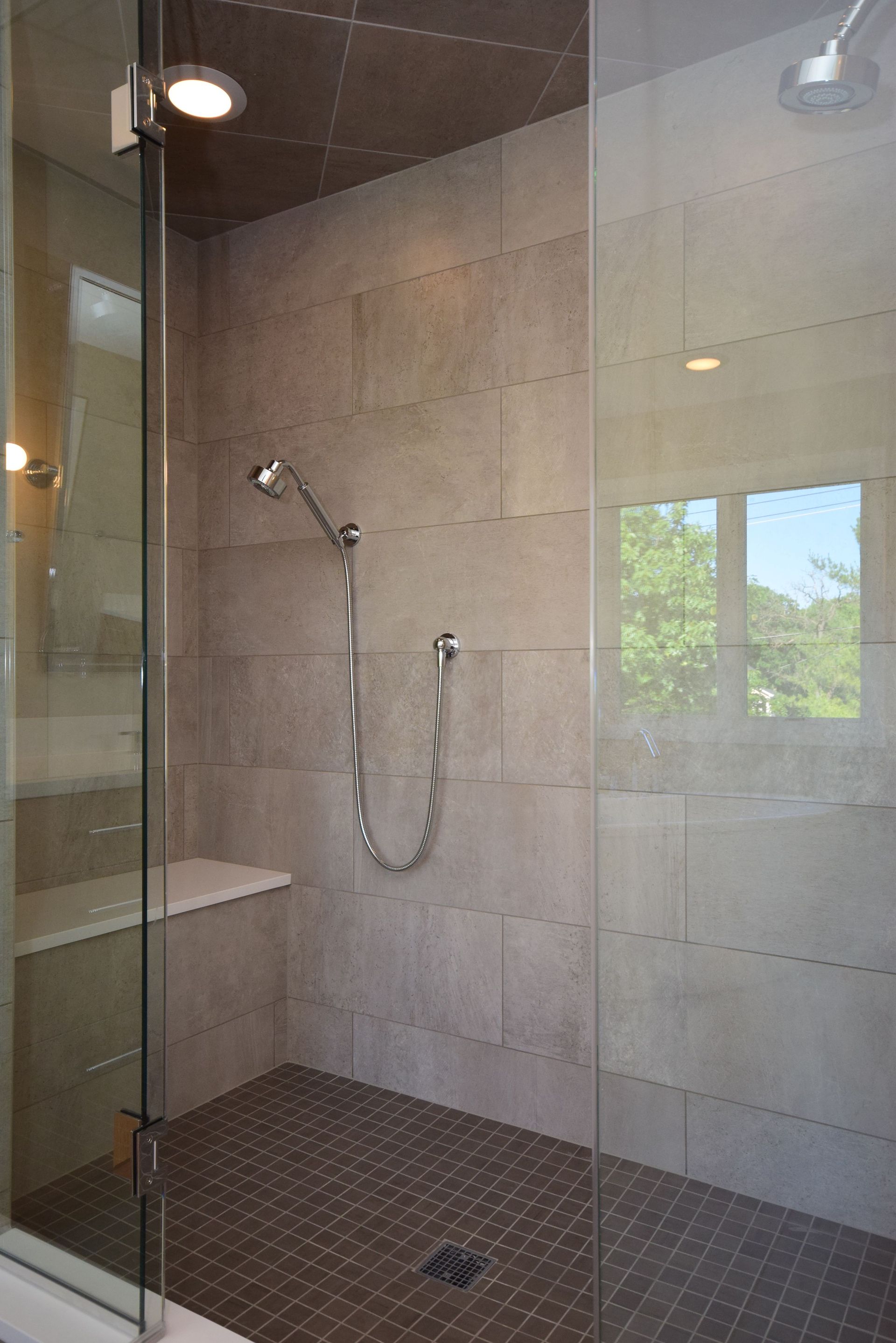 A walk in shower with a glass door and a shower head.