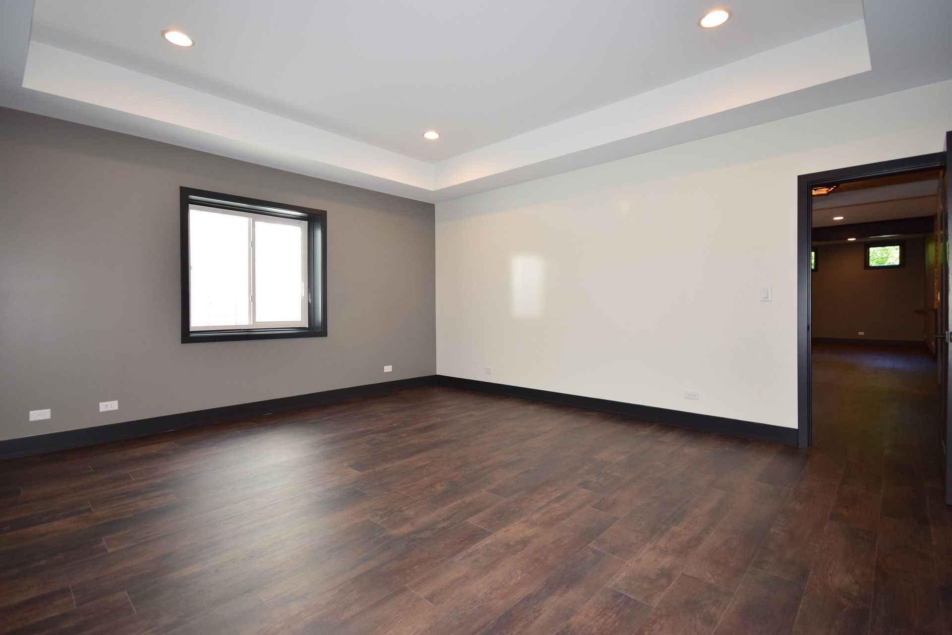 An empty room with hardwood floors and a window