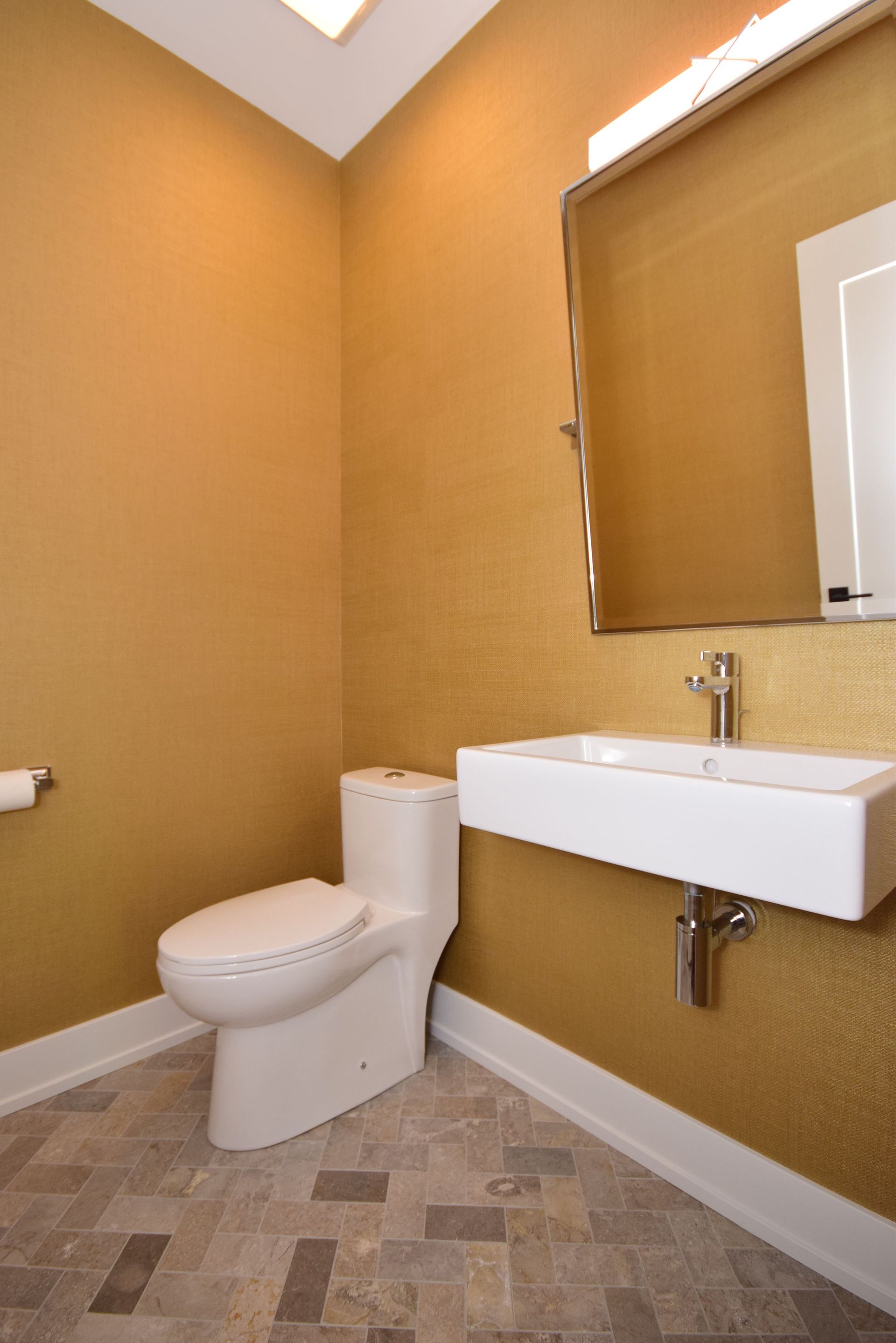 A bathroom with a toilet a sink and a mirror