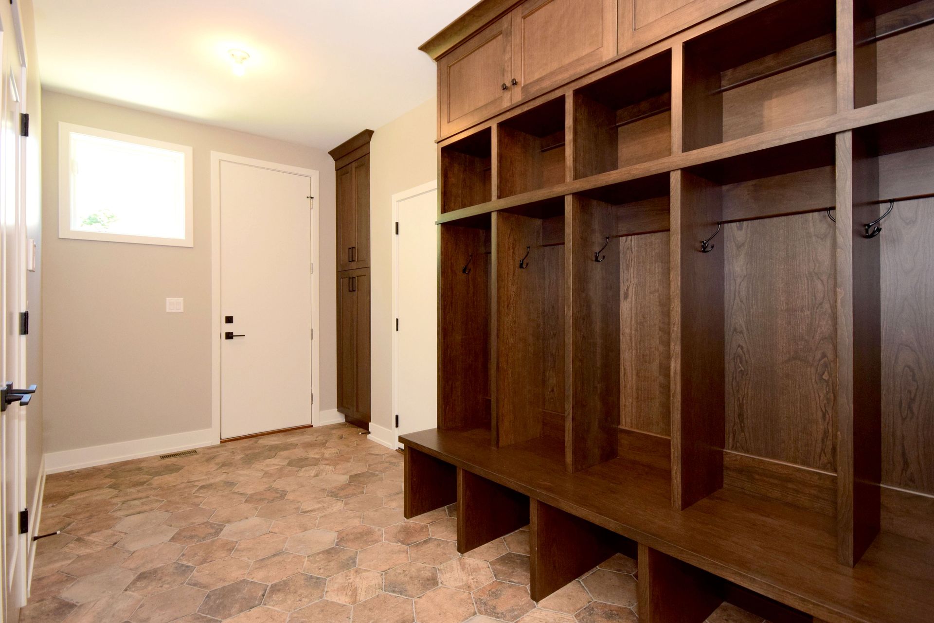 A mud room with lots of shelves and hooks.