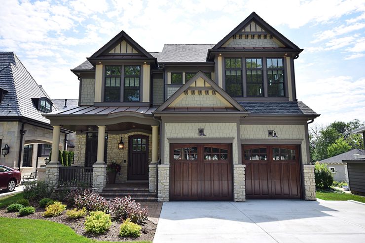 A large house with two garage doors and a large porch.