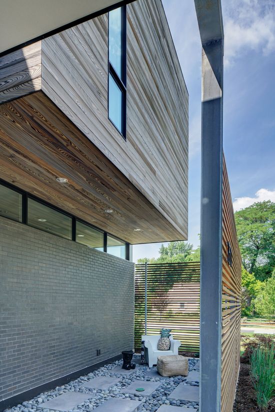 A modern house with a lot of windows and a brick wall.