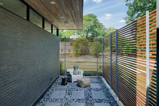A patio with a wooden fence and a brick wall.
