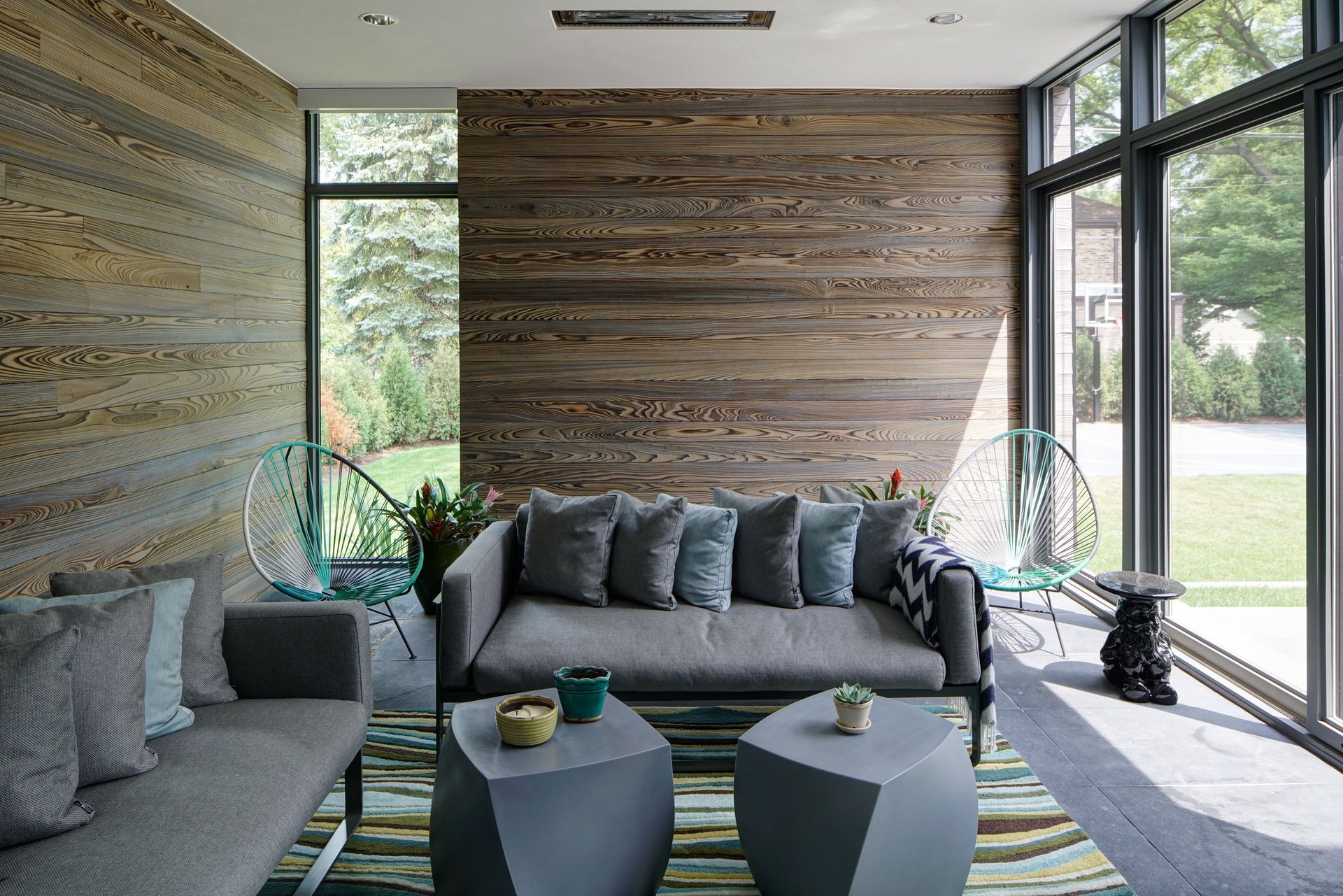 A living room with a couch , two tables , and a large window.