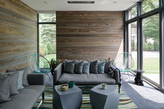 A living room with a couch , two tables , and a large window.
