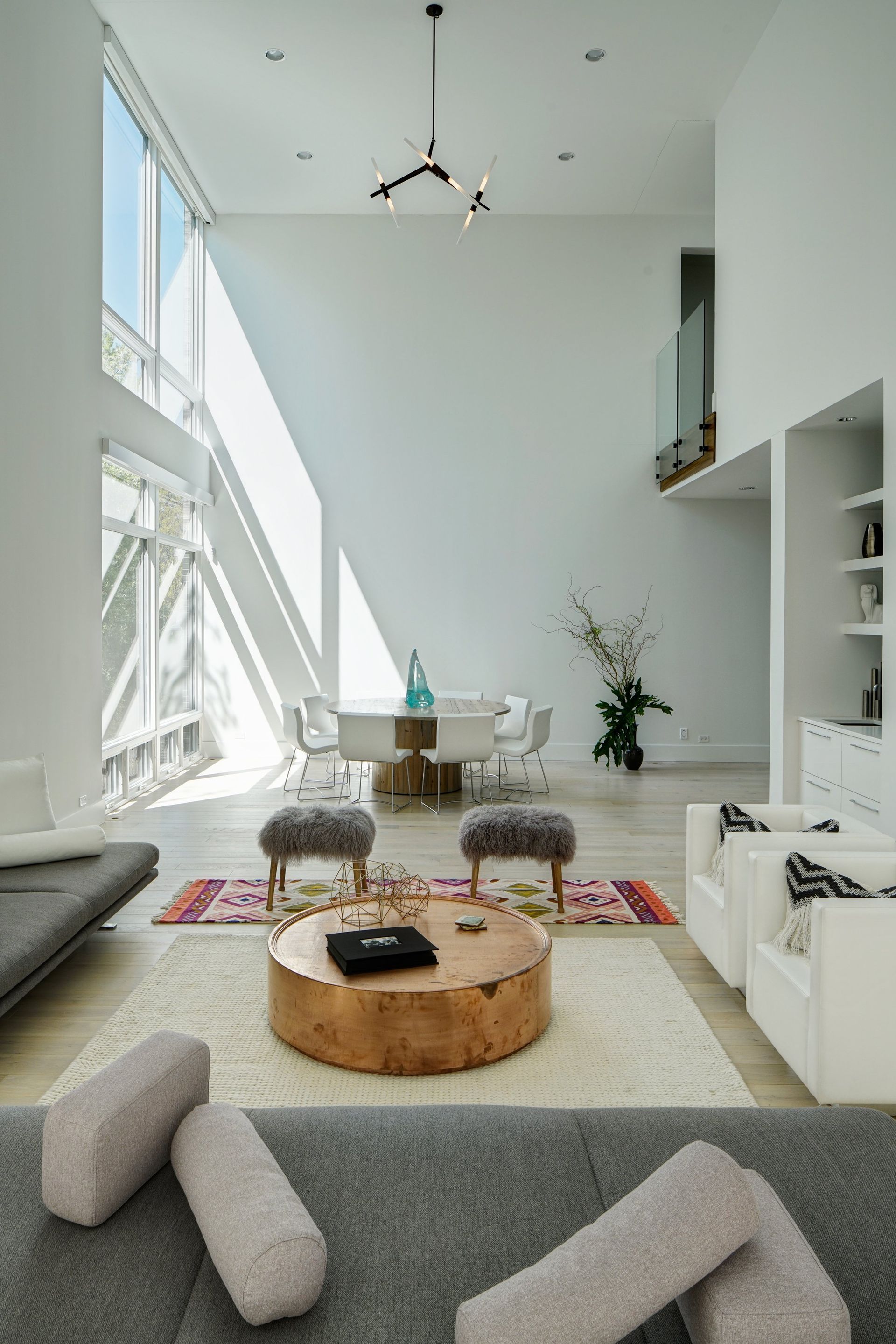 A living room with a round coffee table and a dining room in the background.