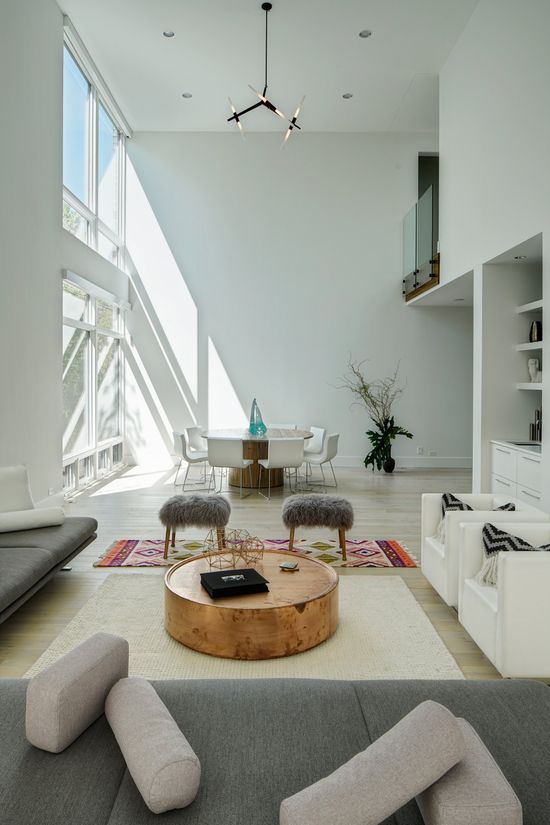 A living room with a round coffee table and a dining room in the background.