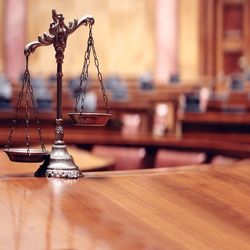 A scale of justice is sitting on a wooden table