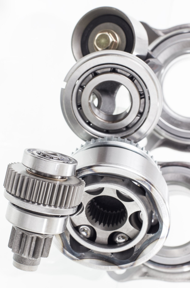 Assorted metal bearings and gears arranged on a white background