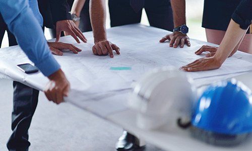 Architect and worker looking building model and blueprint plans Architect and worker looking building model and blueprint plans