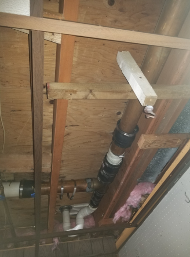 A ceiling with a lot of pipes hanging from it.