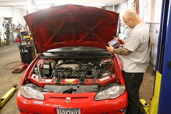 Man Doing Auto Inspection — Minneapolis, MN — Wallace Auto Parts & Repair Man Doing Auto Inspection — Minneapolis, MN — Wallace Auto Parts & Repair