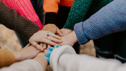 a group of people in a circle with their hand together