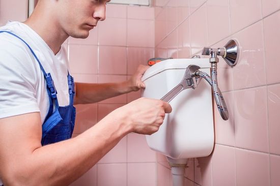Plumber repairing a toilet pipe