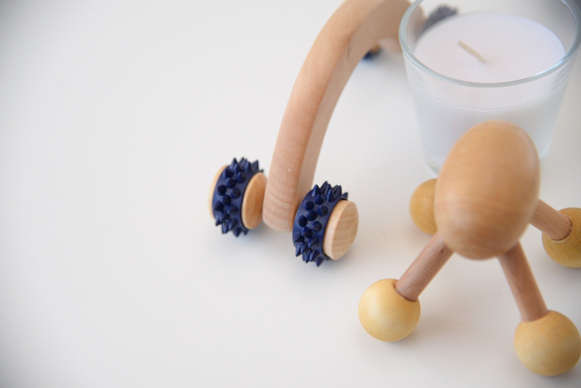 A wooden massage tool is sitting next to a glass of milk.