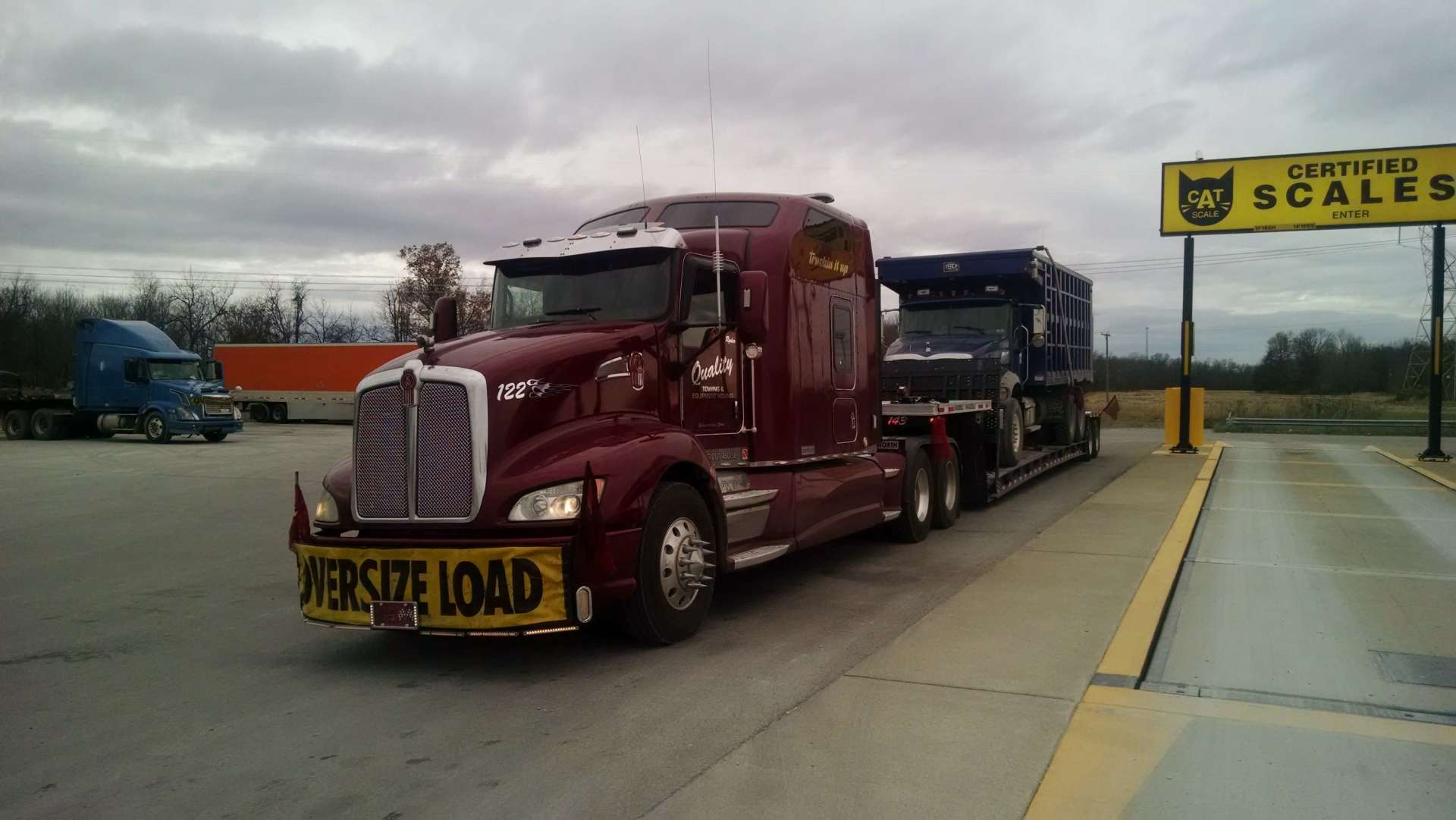 A red semi truck is being weighed at a scale.