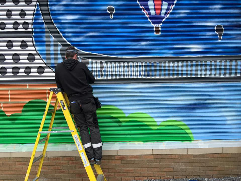 Man painting a roller shutter in Bristol