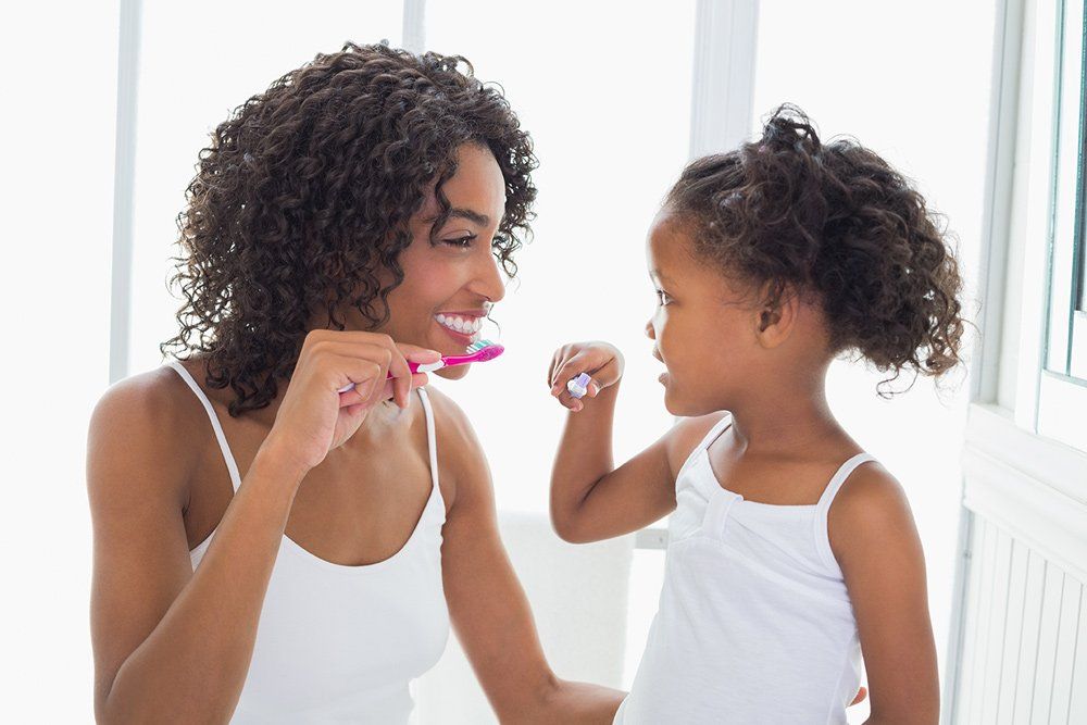 mother daughter brushing teeth