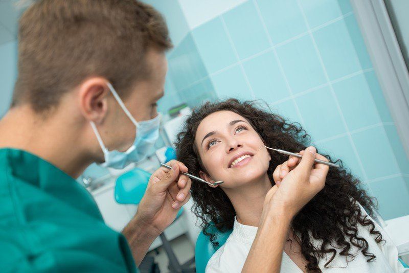dentist cleaning patients teeth