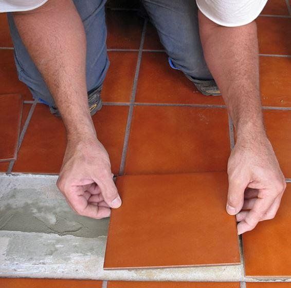 Operaio durante la posa di piastrelle