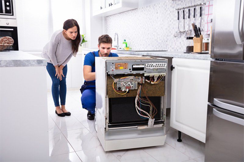 Repair man fixing kitchen appliance