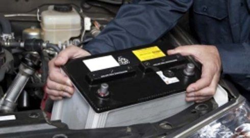 due mani con una batteria di una macchina