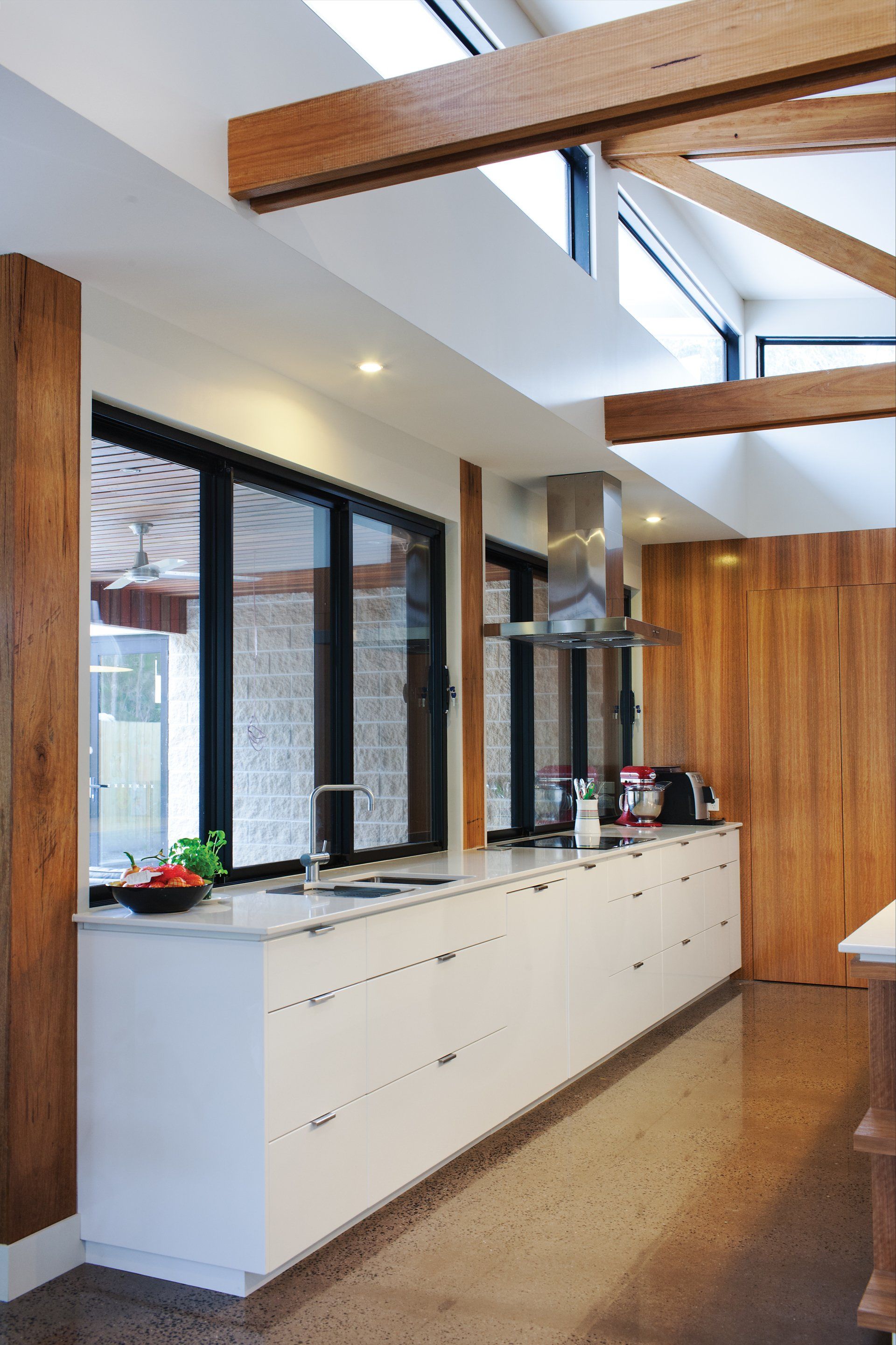 A kitchen with a lot of windows and white cabinets