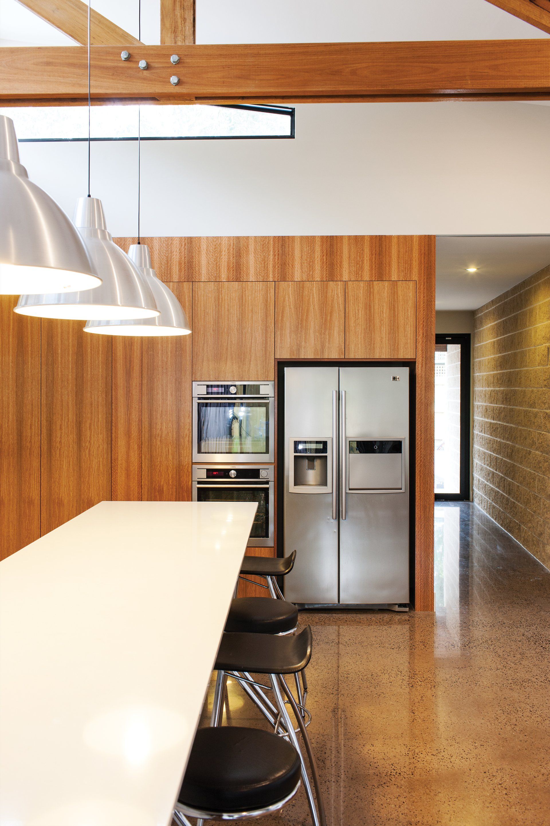 A kitchen with a stainless steel refrigerator and a white counter top.