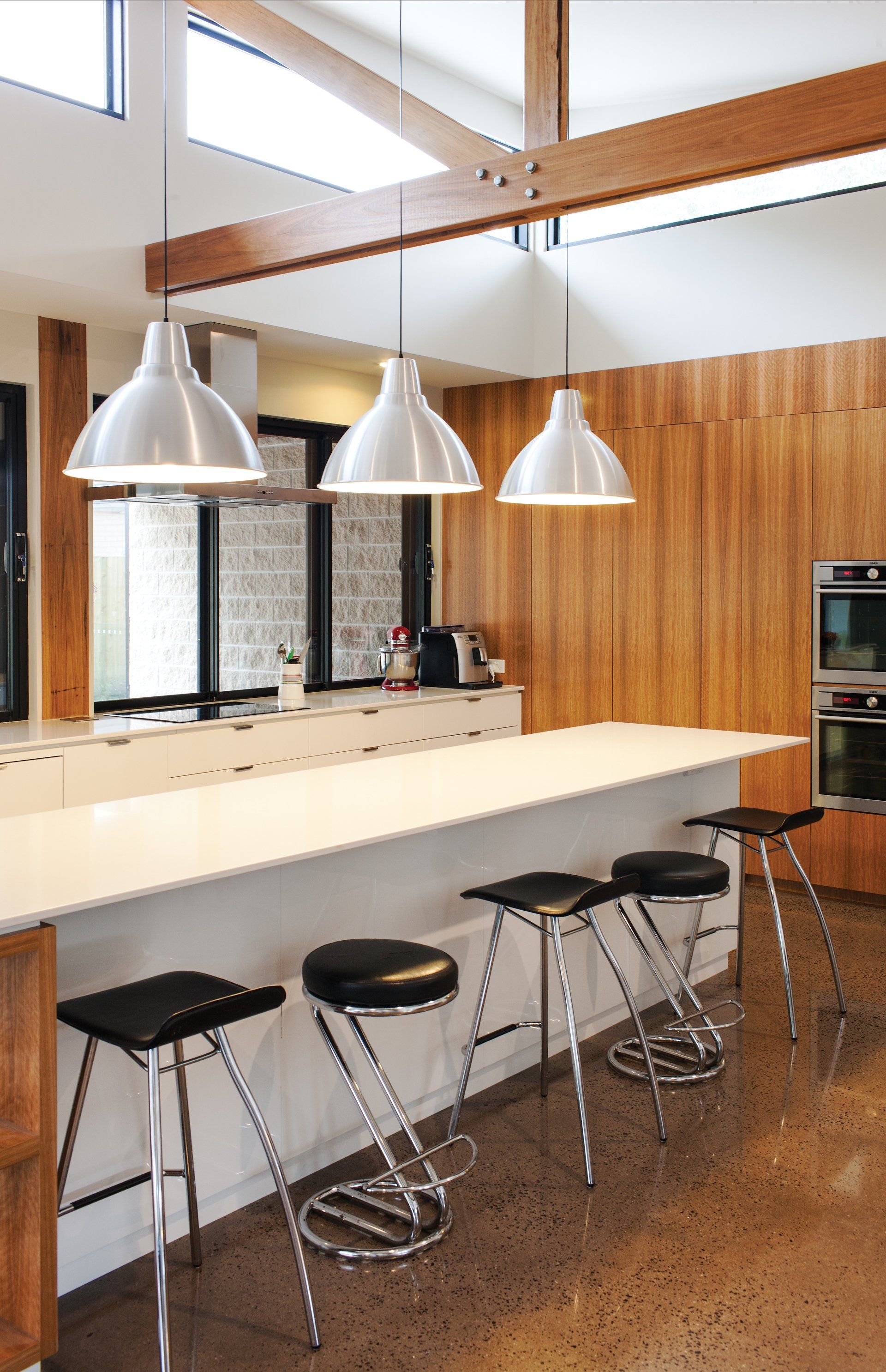 A kitchen with a long counter and stools