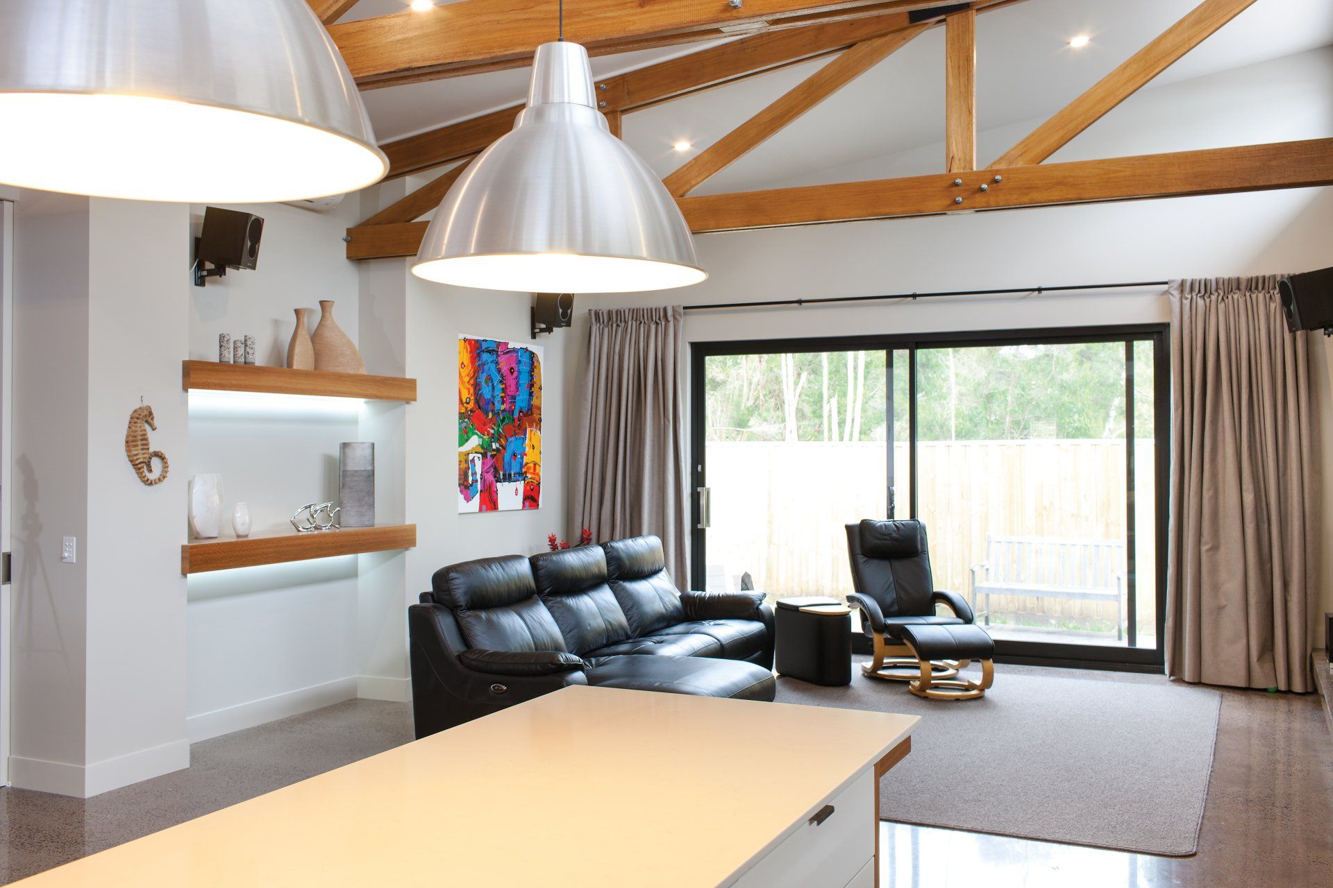 A living room with a black couch and a chair