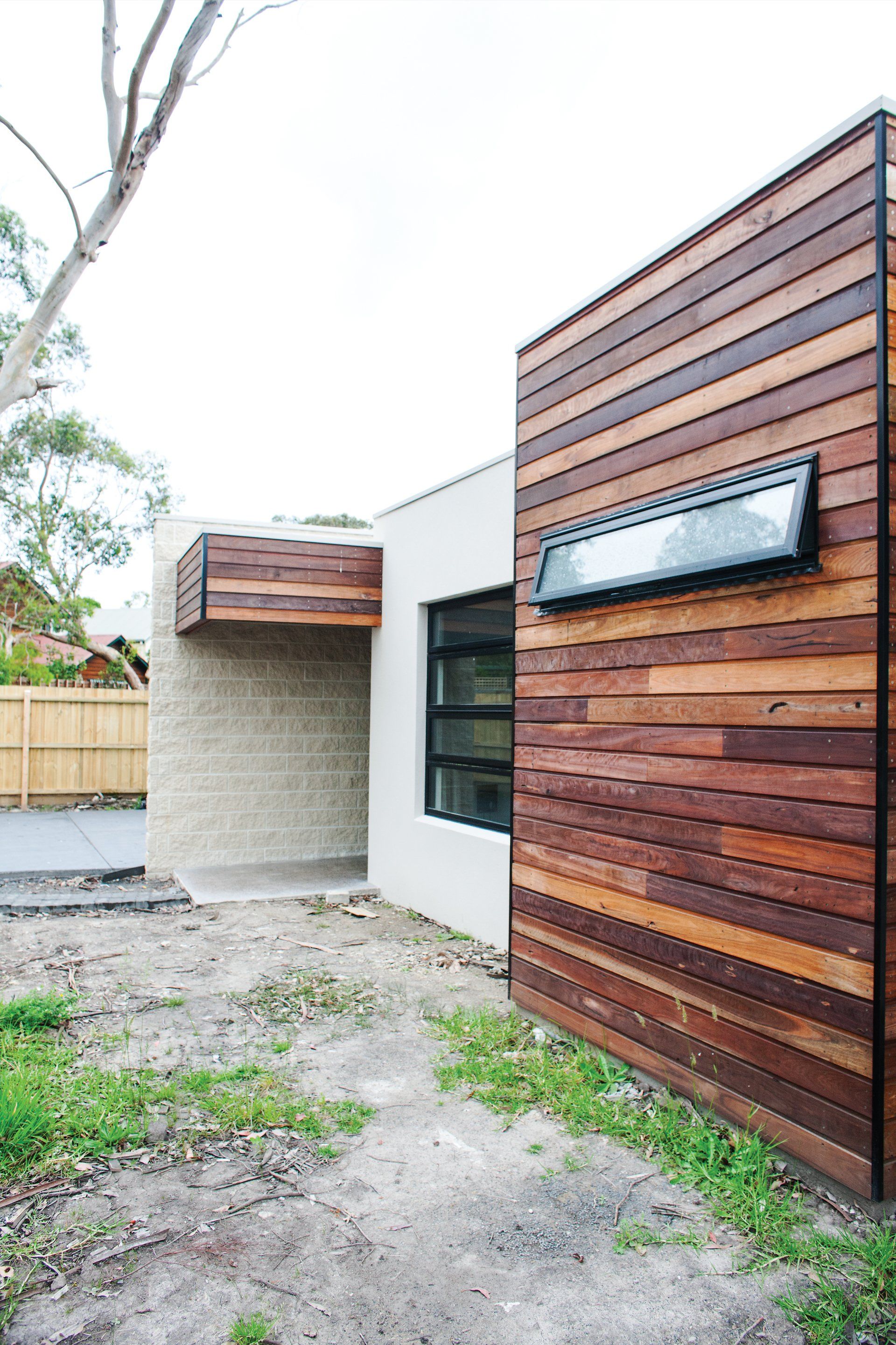 The side of a house with a wooden siding and a window.