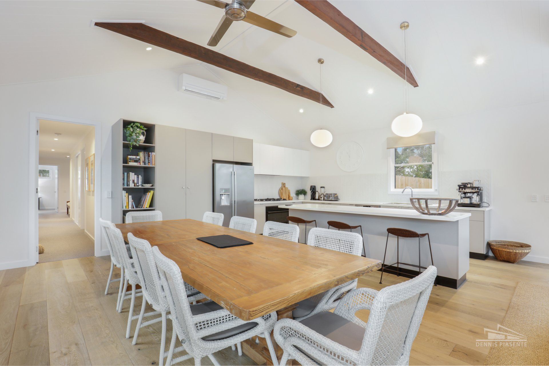 A dining room table and chairs in a kitchen with a ceiling fan.