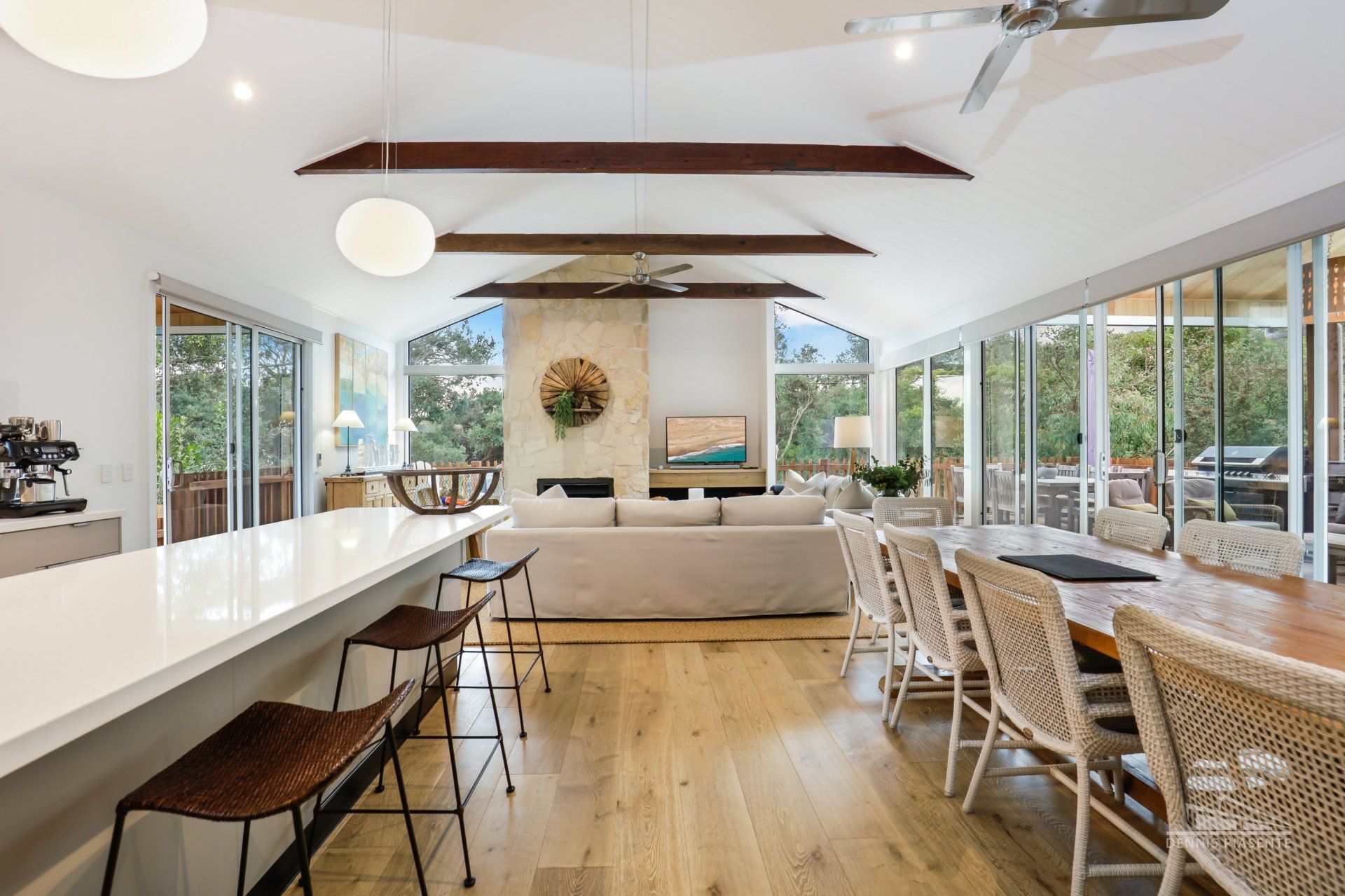 A living room with a couch , table , chairs and a ceiling fan.