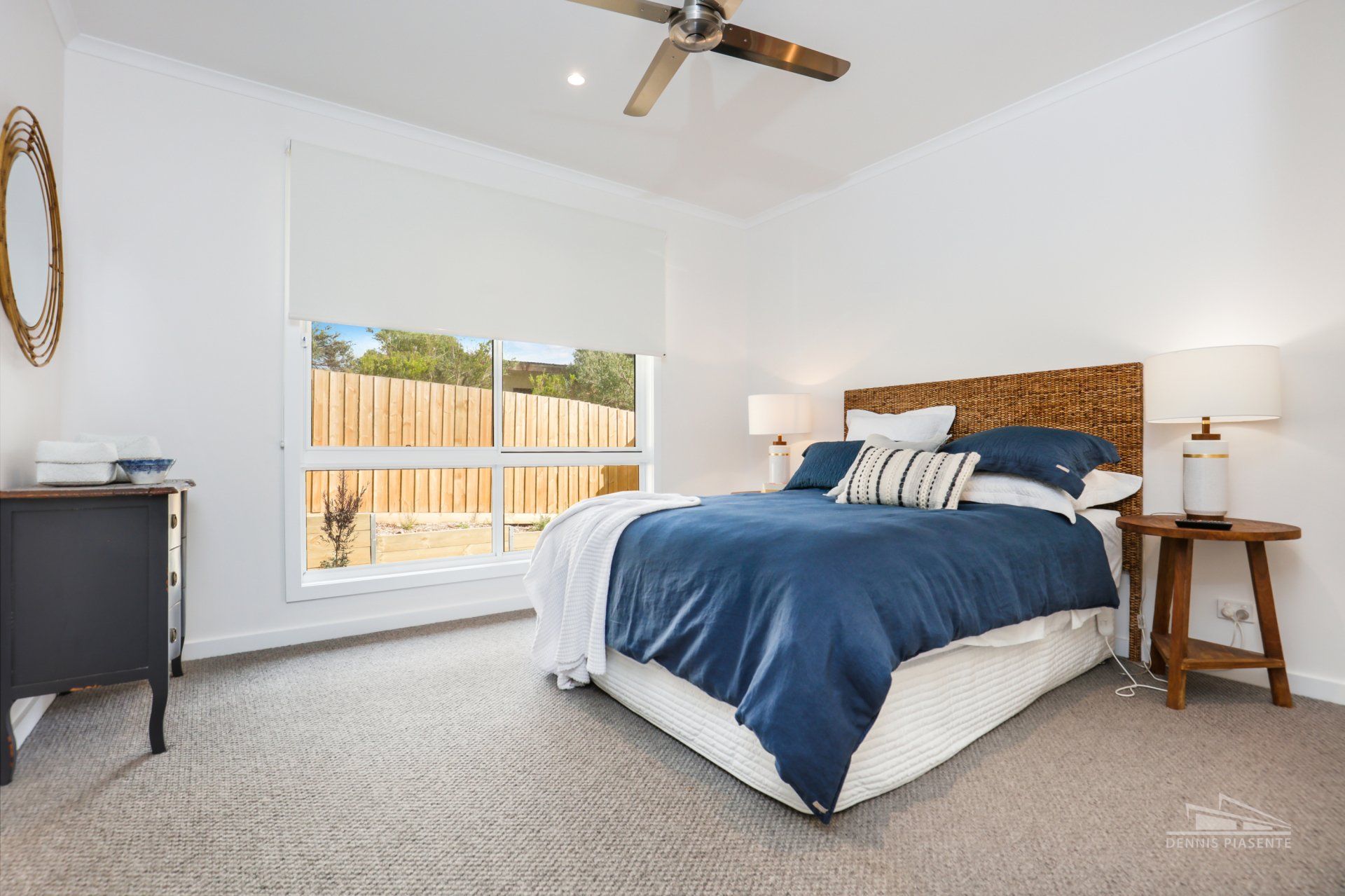 A bedroom with a large bed and a ceiling fan.