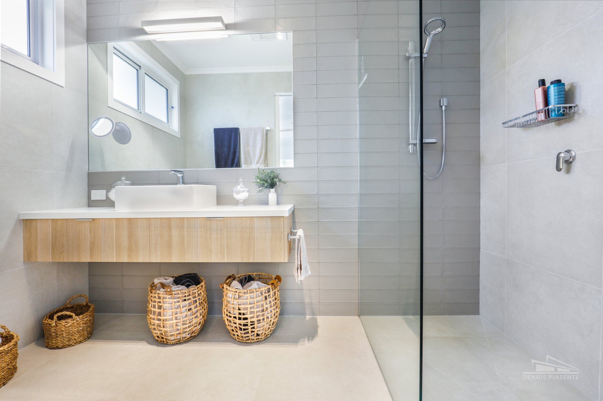 A bathroom with a sink , mirror , and walk in shower.