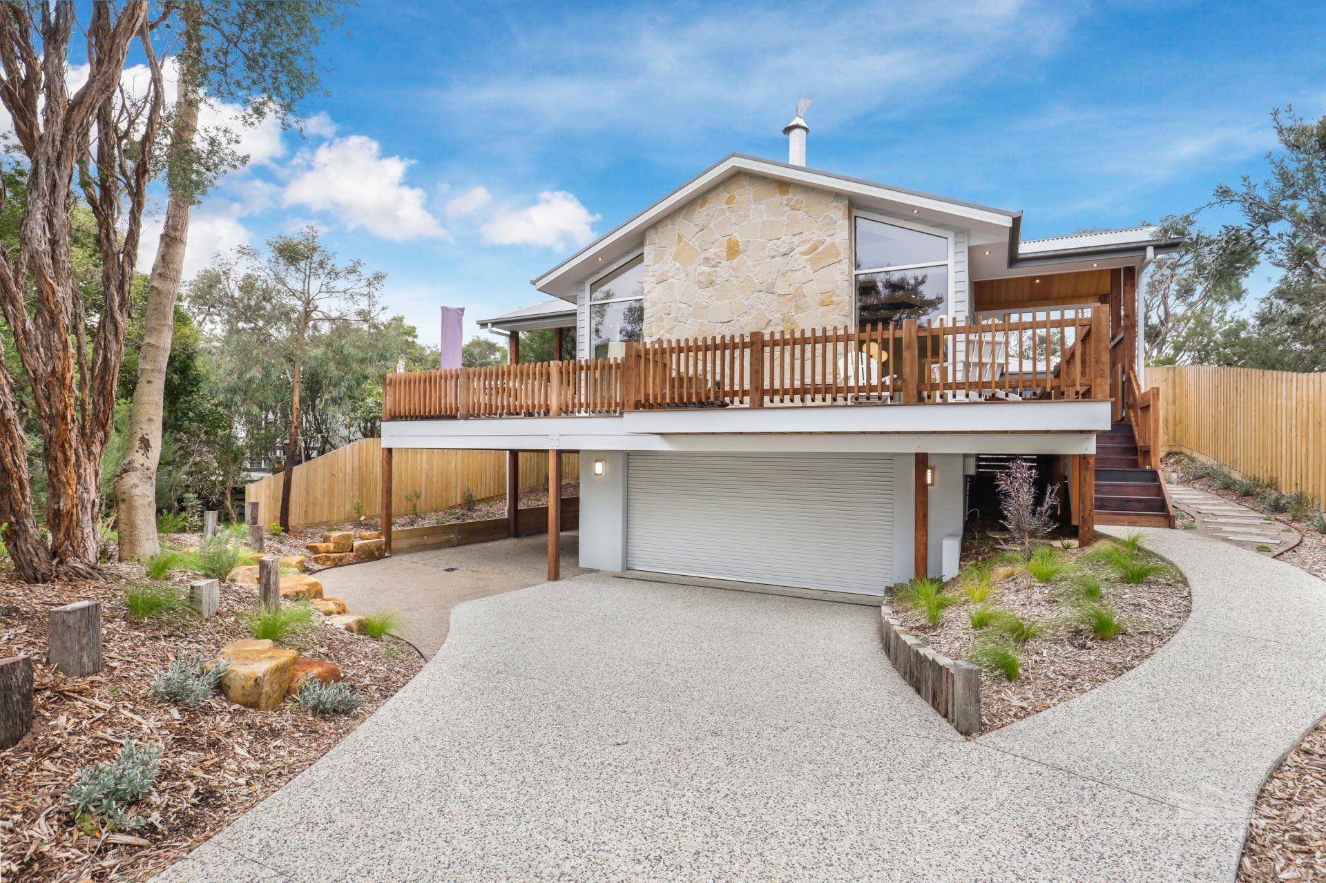 A large house with a large deck and a driveway