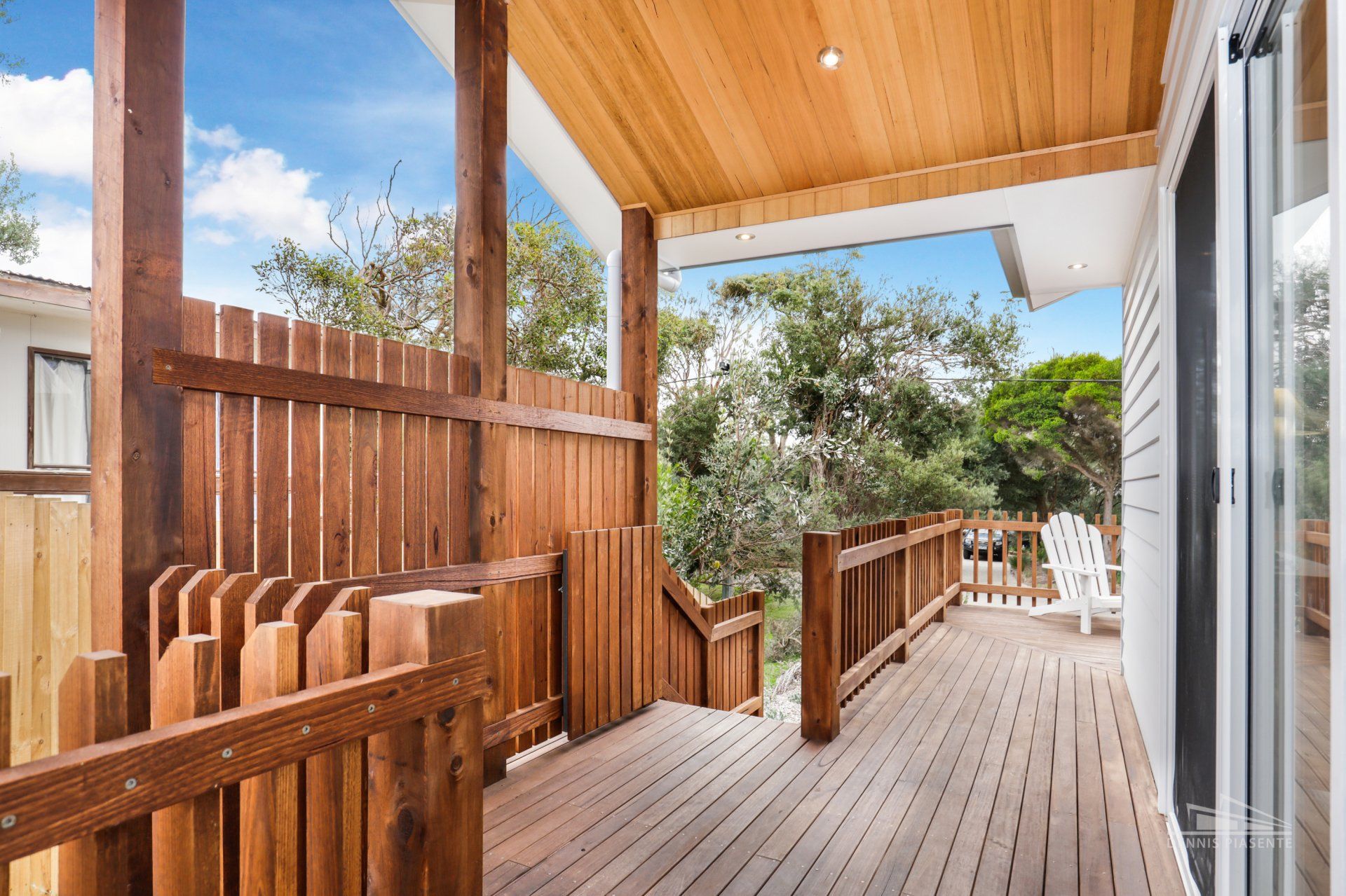 A wooden deck with a fence and chairs on it